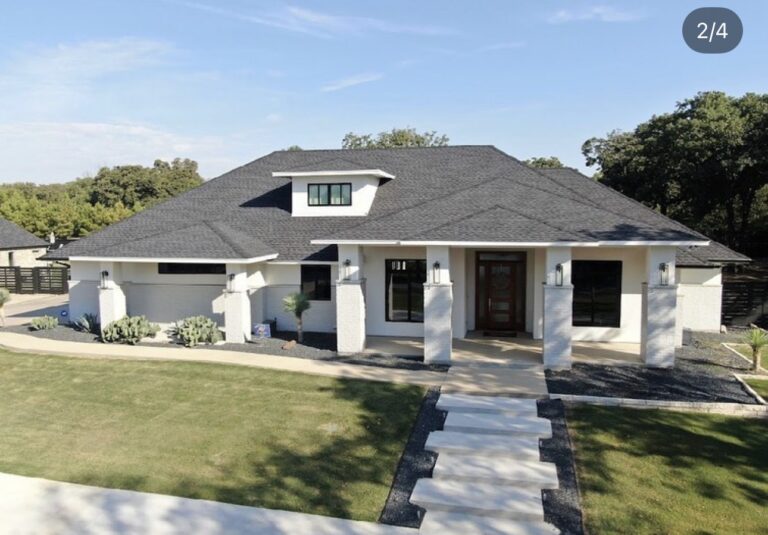 Single-story home with a dark shingle roof and white porch columns