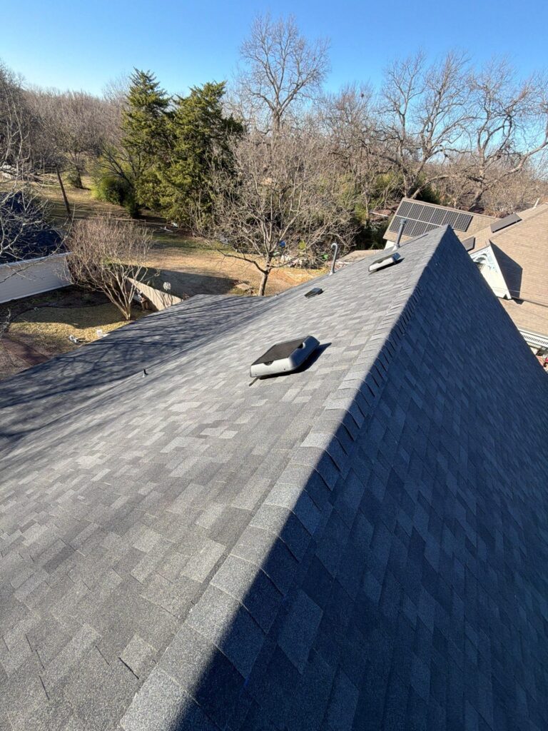 Solar-powered attic vent installed on a gray shingle roof